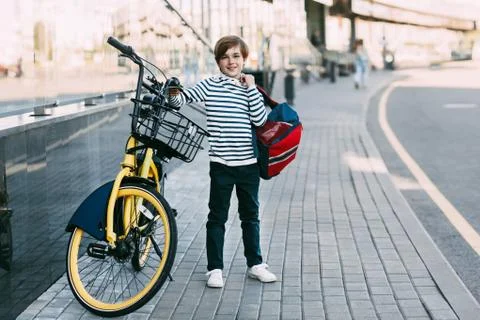 A boy with a backpack on his shoulder is going to go home after school. Safe  Stock Photos