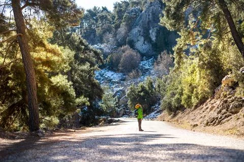 A boy with a backpack in the middle of a forest road, a child is exploring wi Foto stock