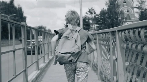 A boy with a backpack runs over the bridge. Cool dynamic shots. slow playback Stock Footage 113071858