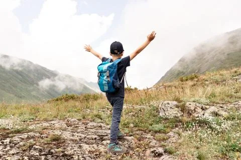 Boy with a backpack on top of a mountain Stock Photos