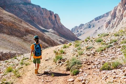 Boy with a backpack walks along a mountain path. the child travels to the mou Foto stock