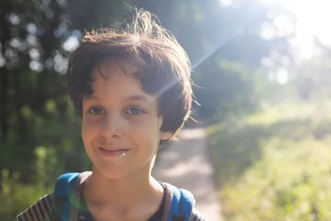 A boy with a backpack walks through the forest, a child explores wildlife, a  Stock Photos