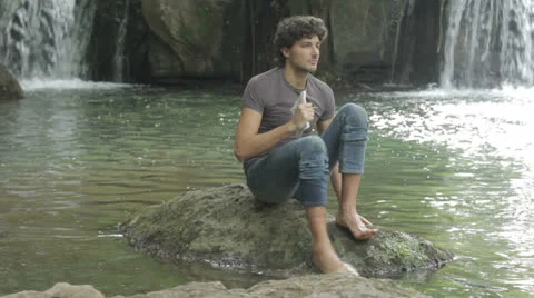 A boy with a backpack writes his thoughts and notes on the nature 库存影片 24768354