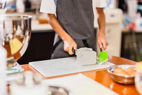Boy baking cake with hand cutting cream cheese in kitchen room. Stock Illustration