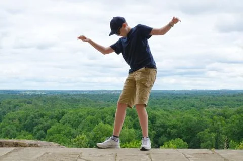 Boy balancing on the edge of a drop - danger concept Stock Photos