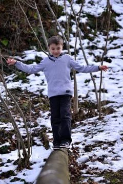 Boy balancing on log in the winter Foto stock