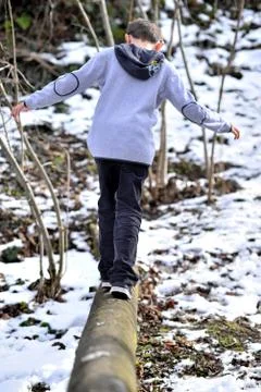 Boy balancing on log in the winter Stock Photos
