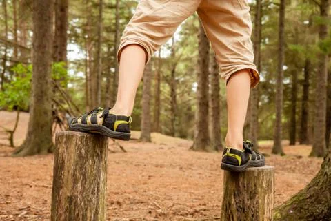 Boy balancing on trees - jumping from one to the other Stock Photos