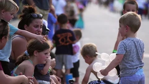 Boy with balloon shows it to a spectator at a parade, in slow motion. Stock-Footage 162646385