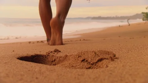 Boy with bare feet leaving his footprints on the sand of a tropical beach Stock Footage 90018098
