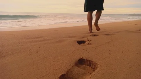 Boy with bare feet leaving his footprints on the sand of a tropical beach Stock Footage 90018160