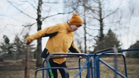 A boy with a baseball bat jumps on a carousel and spins on it 動画素材 126732006