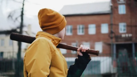 A boy with a baseball bat rides in a circle on a carousel. A cheeky teenager. 動画素材 126732025