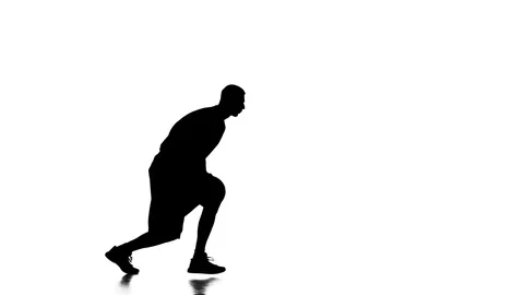 Boy basketball player makes a feint with the ball. Silhouette Stock Footage 70490606