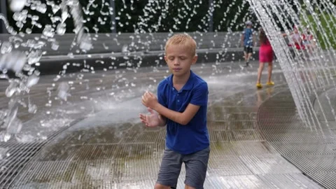 A boy is bathing and having fun in the fountain on a hot summer day. Stock Footage 295191615