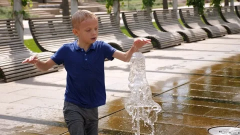 A boy is bathing and having fun in the fountain on a hot summer day. Stock Footage 295843503