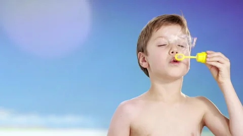 Boy at beach blowing bubbles Vidéo 60945917