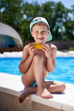 Boy on the beach eating corn on the beach Stock Photos