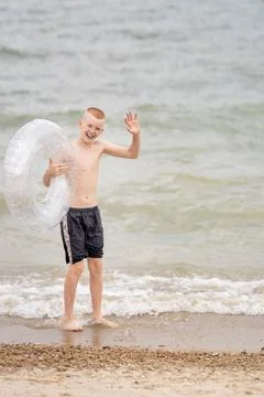 Boy on the beach with an inflatable ring Stock Photos