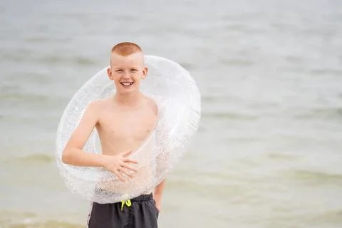 Boy on the beach with an inflatable ring Foto stock