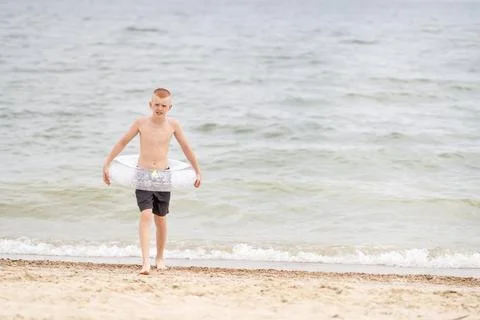 Boy on the beach with an inflatable ring Stock Photos