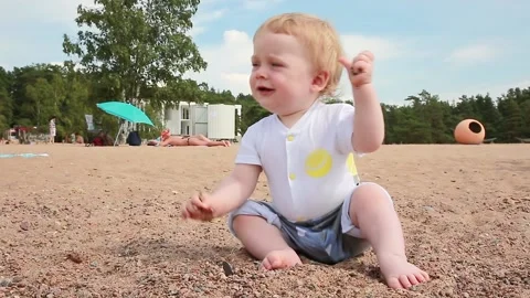 A boy on the beach playing with small stones Video stock 135732967