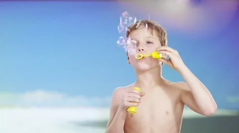 Boy at beach playing with soap bubbles Vidéo 60946165