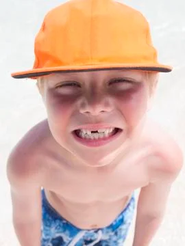Boy on beach wearing orange cap Stock Photos