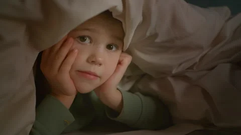 The boy in bed is looking at the phone. Stock Footage 260894559