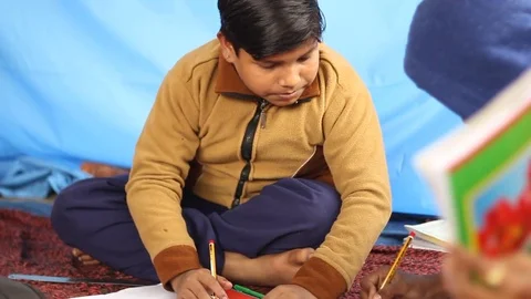 Boy in beige sweater studies in Indian village school. Stock Footage 84732428