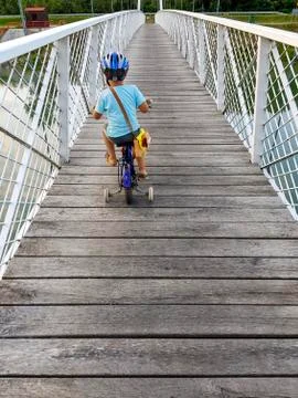 A boy with bicycle on a bridge 库存照片