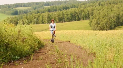 Boy With Bicycle,  Young man with bicycle in a wheat field Stock Footage 45741483