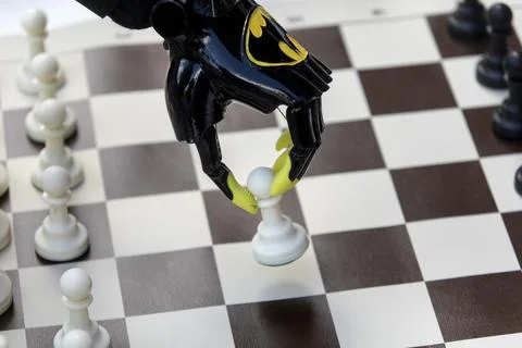 A boy with a bionic prosthetic arm plays chess Stock Photos