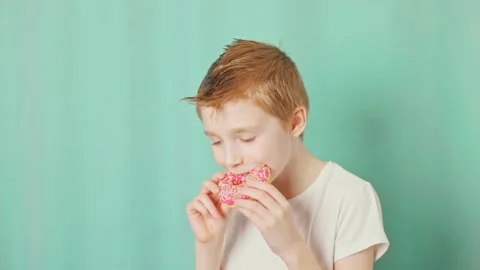 Boy bites off a donut Stock Footage 232810110