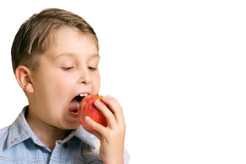 Boy biting into an apple Stock Photos