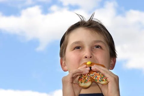 Boy biting into donut Stock Photos