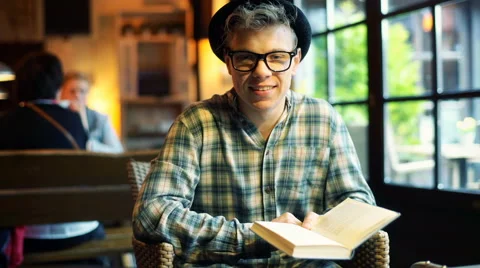 Boy in black hat holding a book and smiling to the camera Stock-Footage 62410163