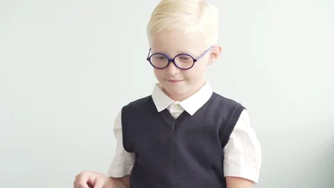 The boy blond puts a school backpack on his shoulders Stock Footage 93875390