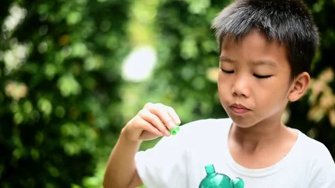 Boy blow a soap bubble in the garden 스톡 동영상 79335856