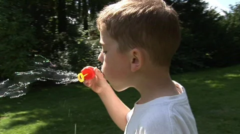 Boy blowing bubbles Stock Footage 506378