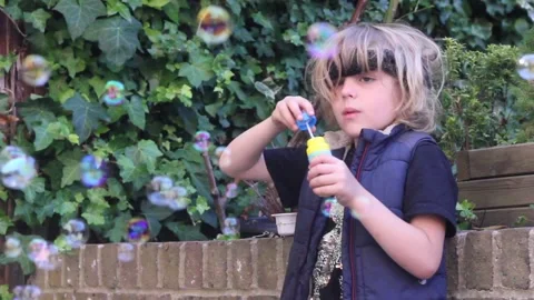 Boy blowing bubbles Stock Footage 137959727