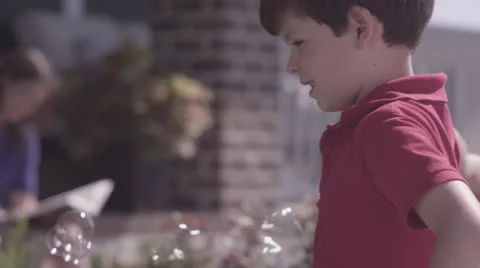 Boy Blowing Bubbles in Front Yard 2 Stock Footage 25933649