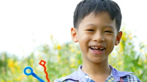 Boy blowing bubbles in garden Stock Footage 54379466