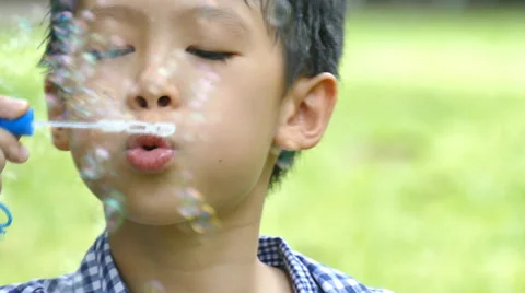 Boy blowing bubbles in garden Stock Footage 55803272