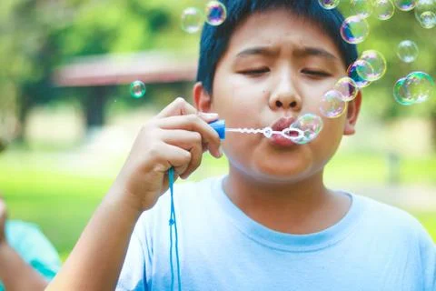 Boy blowing bubbles in the garden Stock Photos