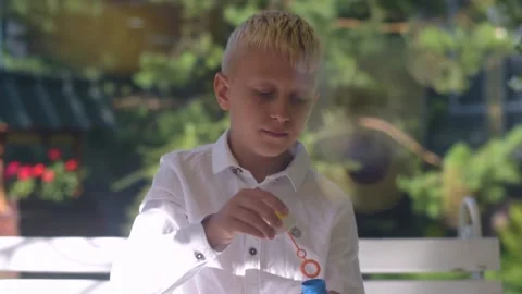 Boy Blowing Bubbles. A little Boy is having fun Blowing party bubbles. Stock Footage 161410330