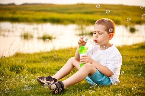 Boy blowing bubbles in the park Stock Photos