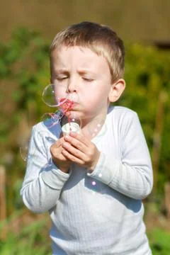 Boy blowing bubbles Stock Photos