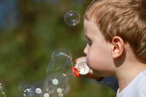 Boy blowing bubbles Stock Photos