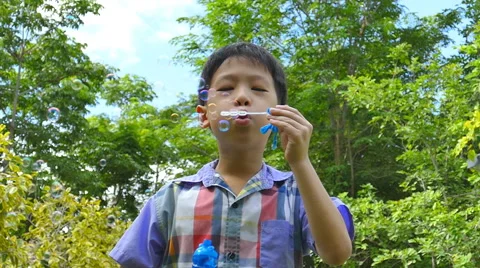 Boy blowing bubbles, slow motion Stock Footage 52817016